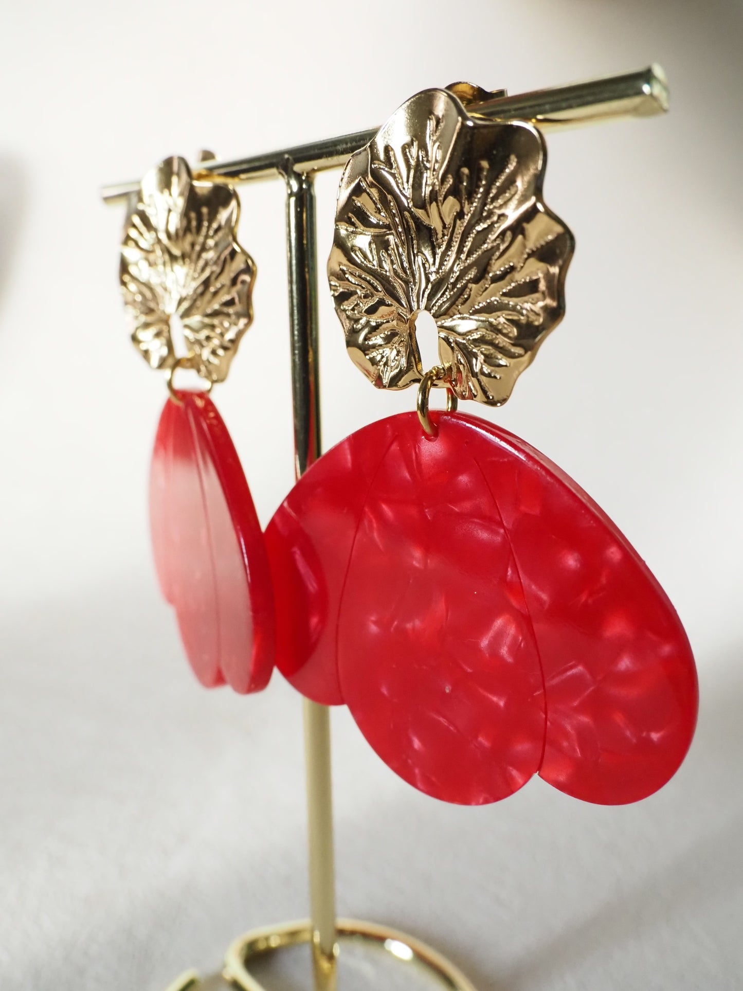 Boucles d’oreilles pendantes LIA – Clous feuille en acier inoxydable doré & pétales en acrylique rouge marbré